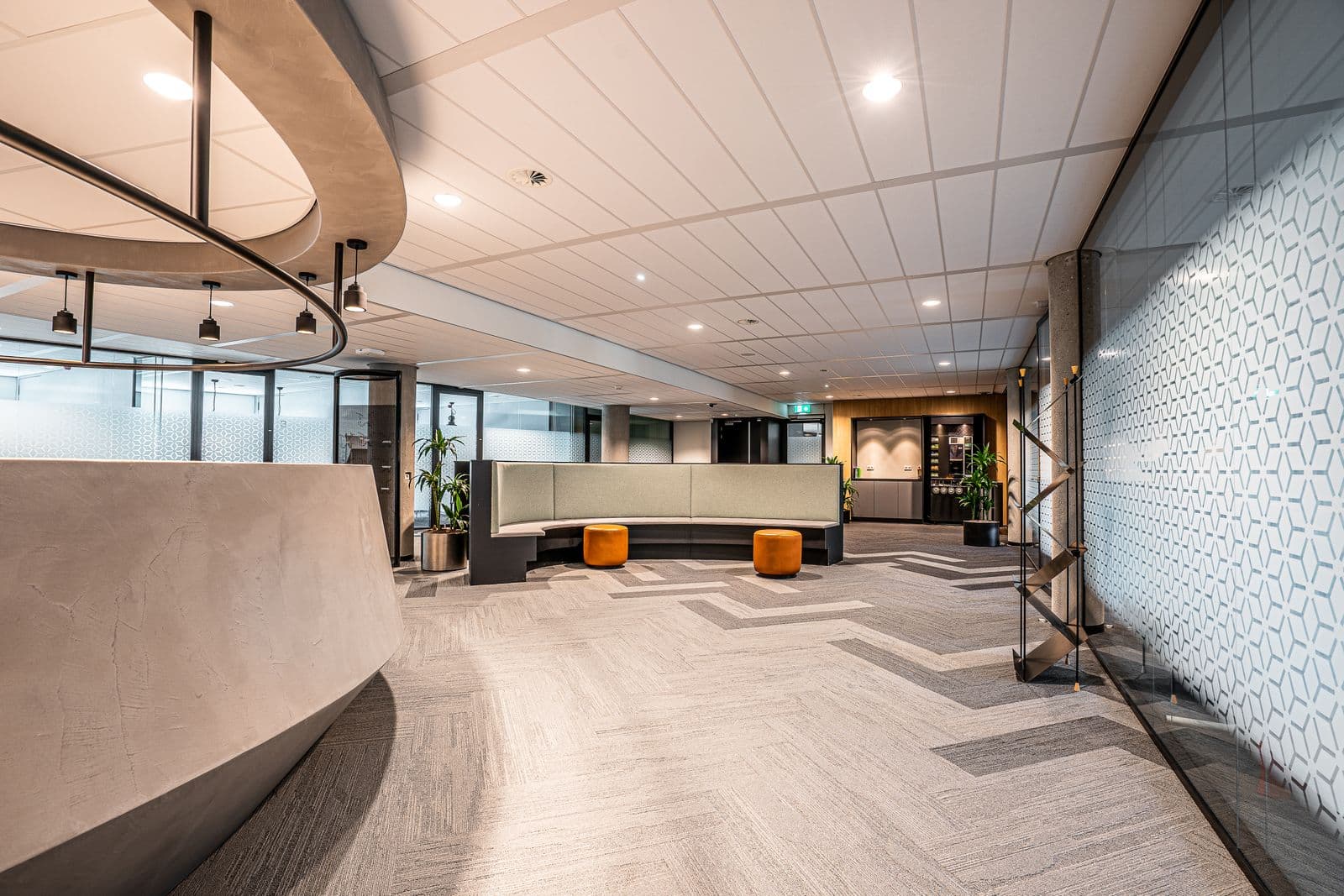Modern office reception with a curved desk and waiting seating